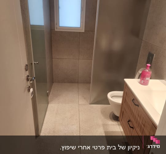 בקבוק סבון ורוד על כיור בחדר אמבטיה